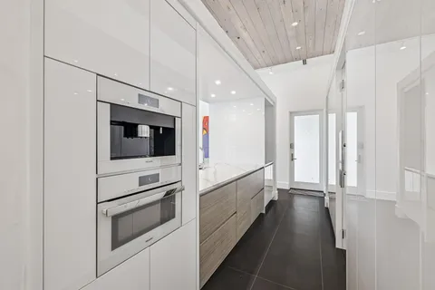 a spacious bedroom with a large bed and a flat tv screen on dresser