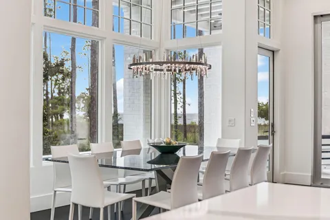 a view of a white house with a yard and potted plants