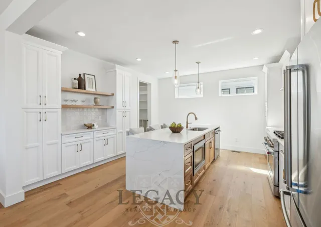 a kitchen with white cabinets and stainless steel appliances