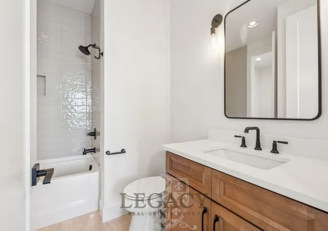 a bathroom with a sink a toilet a mirror and shower