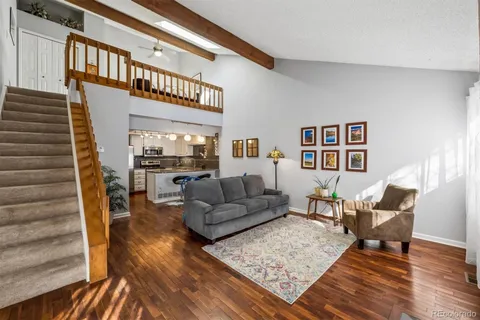 a living room with furniture and a wooden floor