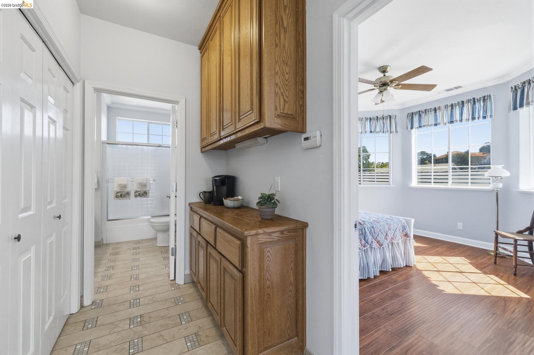 6242 Bluff View Road Copperopolis, CA 95228 - Photo 40 of 59 Hallway featuring wood-finish cabinetry with a built-in counter, patterned tile flooring, and bi-fold closet doors to the upstairs laundry