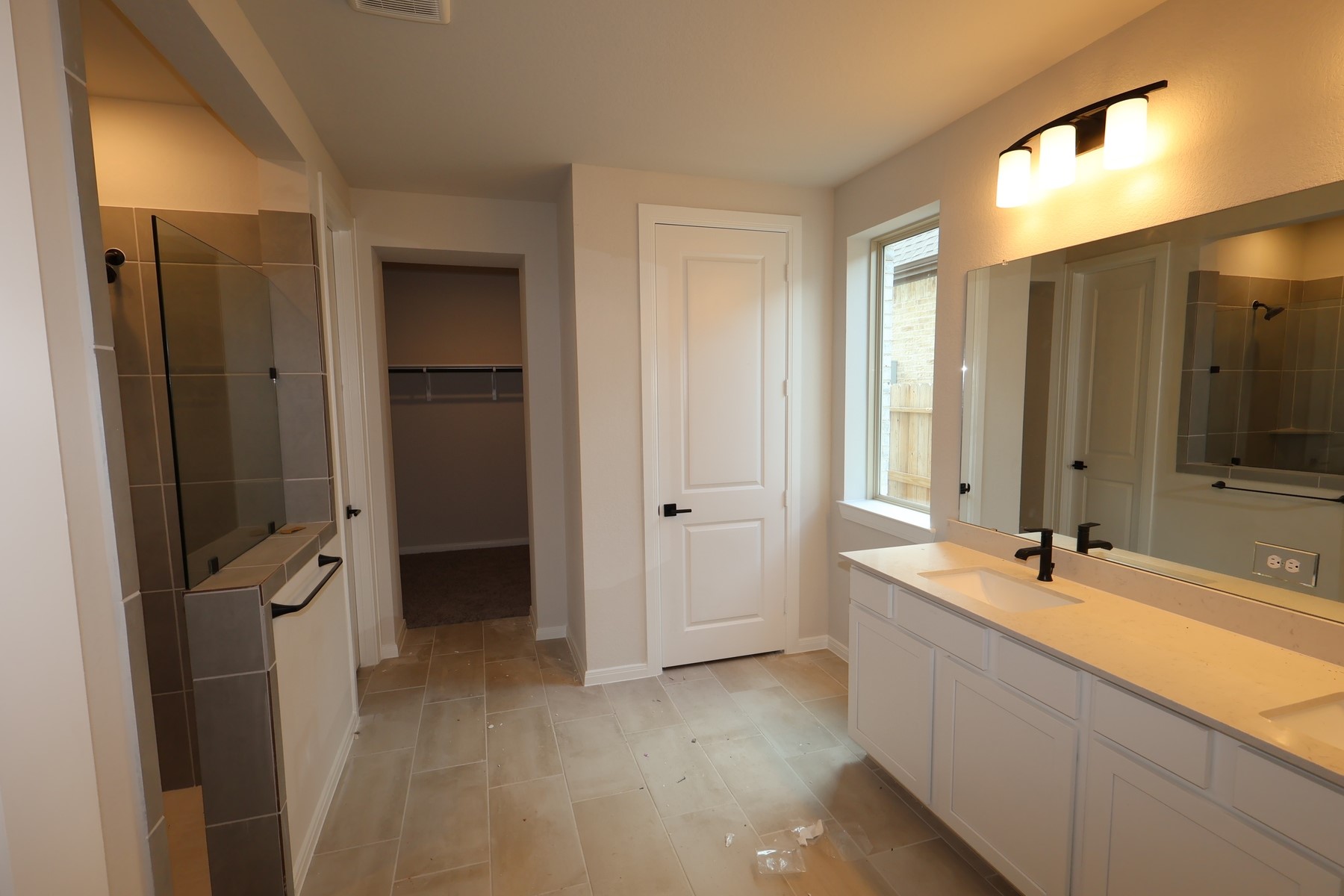 42568 Edmund Rucker Lane Magnolia, TX 77354 - Photo 11 of 18 a bathroom with a double vanity sink a mirror and a bathtub