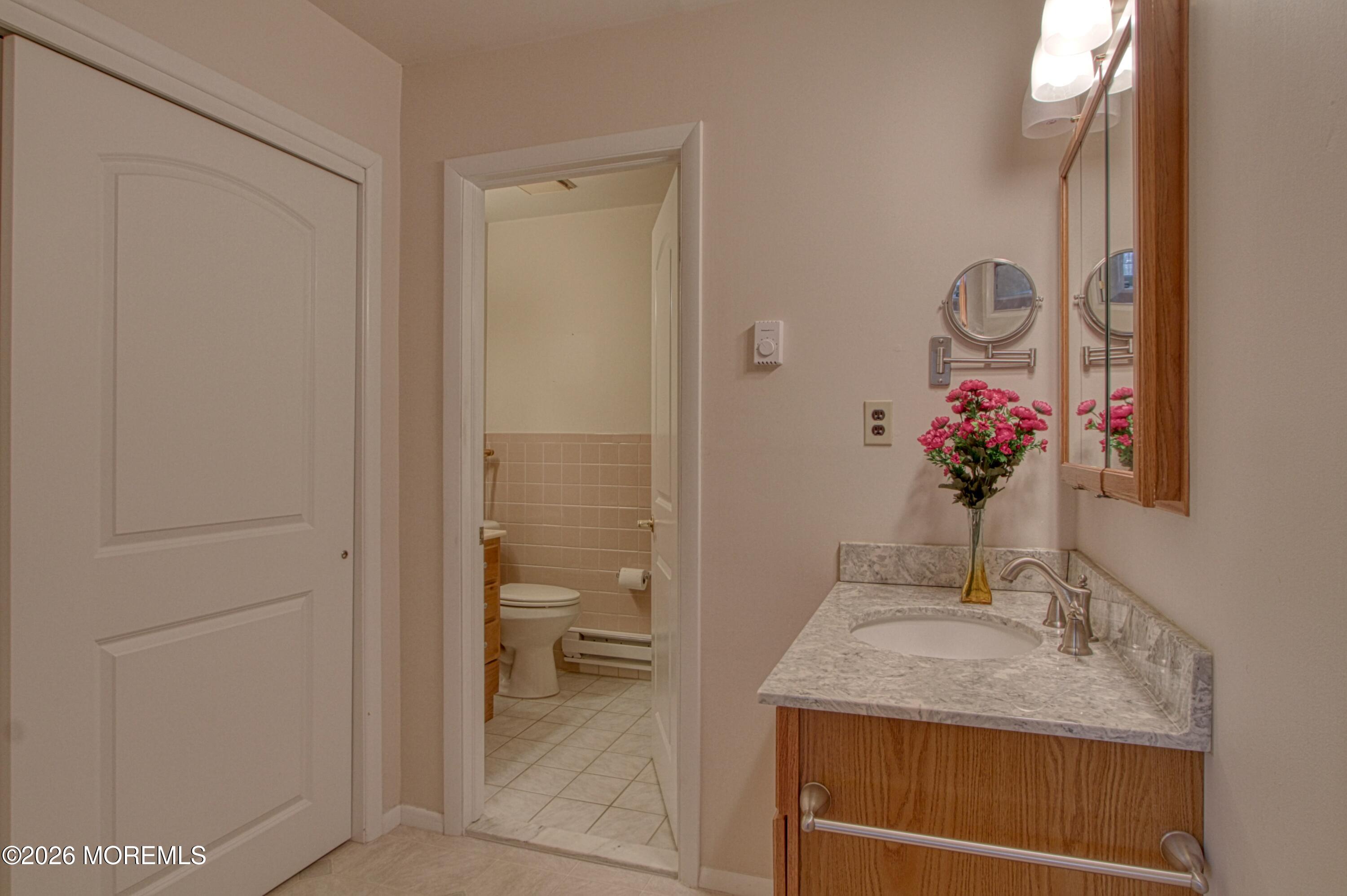 12 Homestead Drive, Unit A Whiting, NJ 08759 - Photo 9 of 18 a bathroom with a granite countertop sink a mirror and a shower