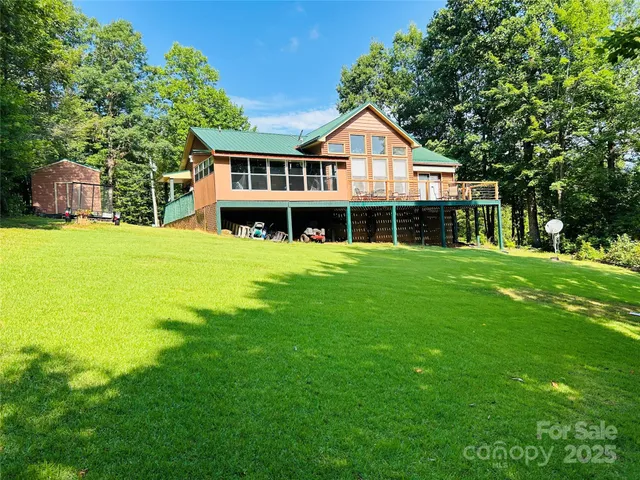 a view of a house with a big yard and large trees
