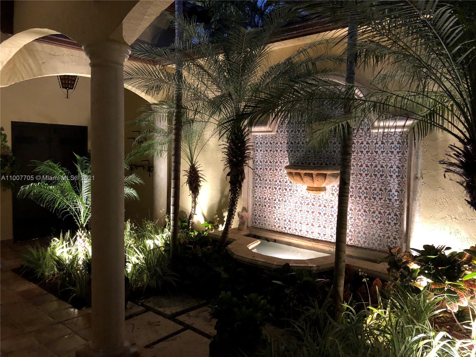 1385 North Biscayne Point Road Miami Beach, FL 33141 - Photo 33 of 68 a backyard of a house with table and chairs potted plants