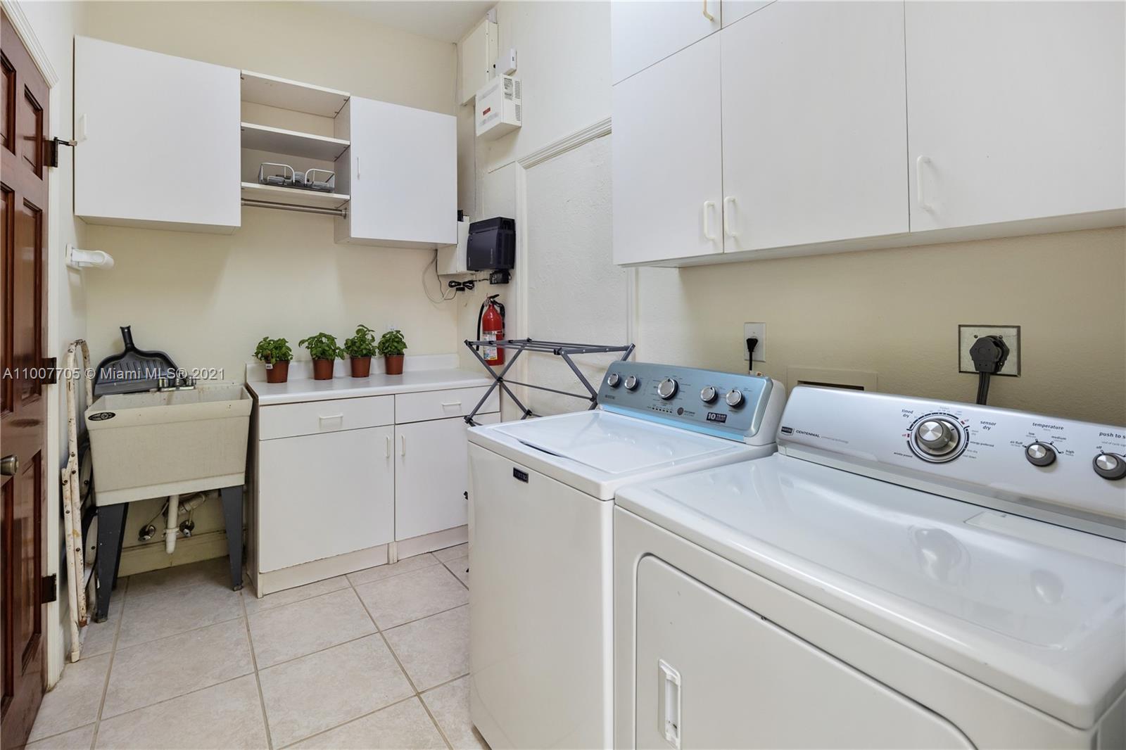 1385 North Biscayne Point Road Miami Beach, FL 33141 - Photo 54 of 68 a utility room with cabinets washer and dryer