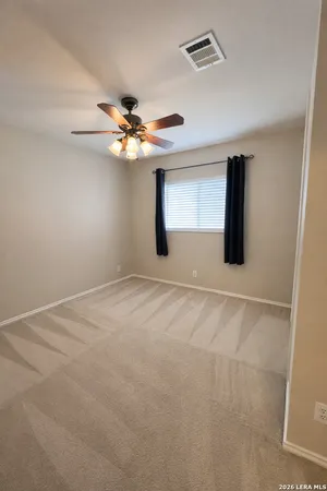 an empty room with windows and fan