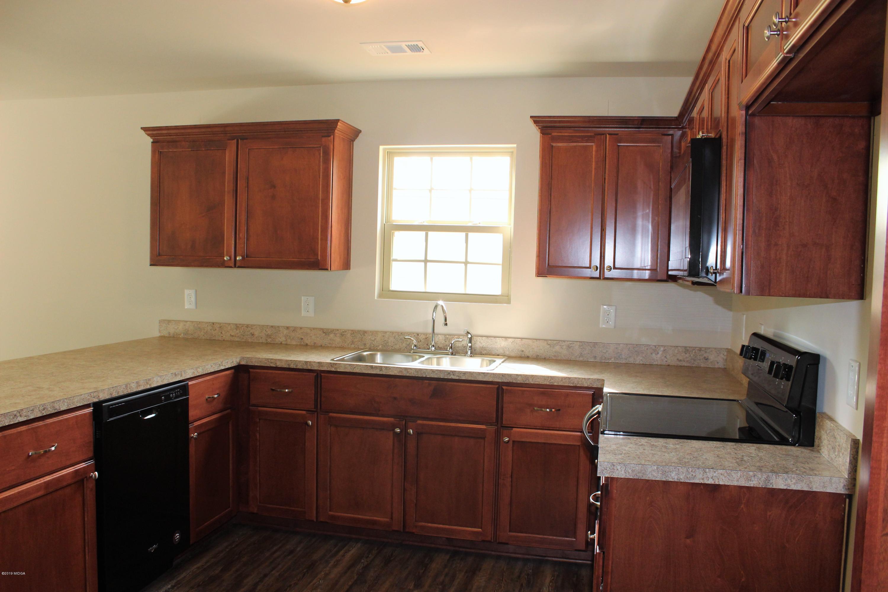 805 Weldon Road Forsyth, GA 31029 - Photo 3 of 5 a kitchen with stainless steel appliances granite countertop wooden cabinets a sink and dishwasher