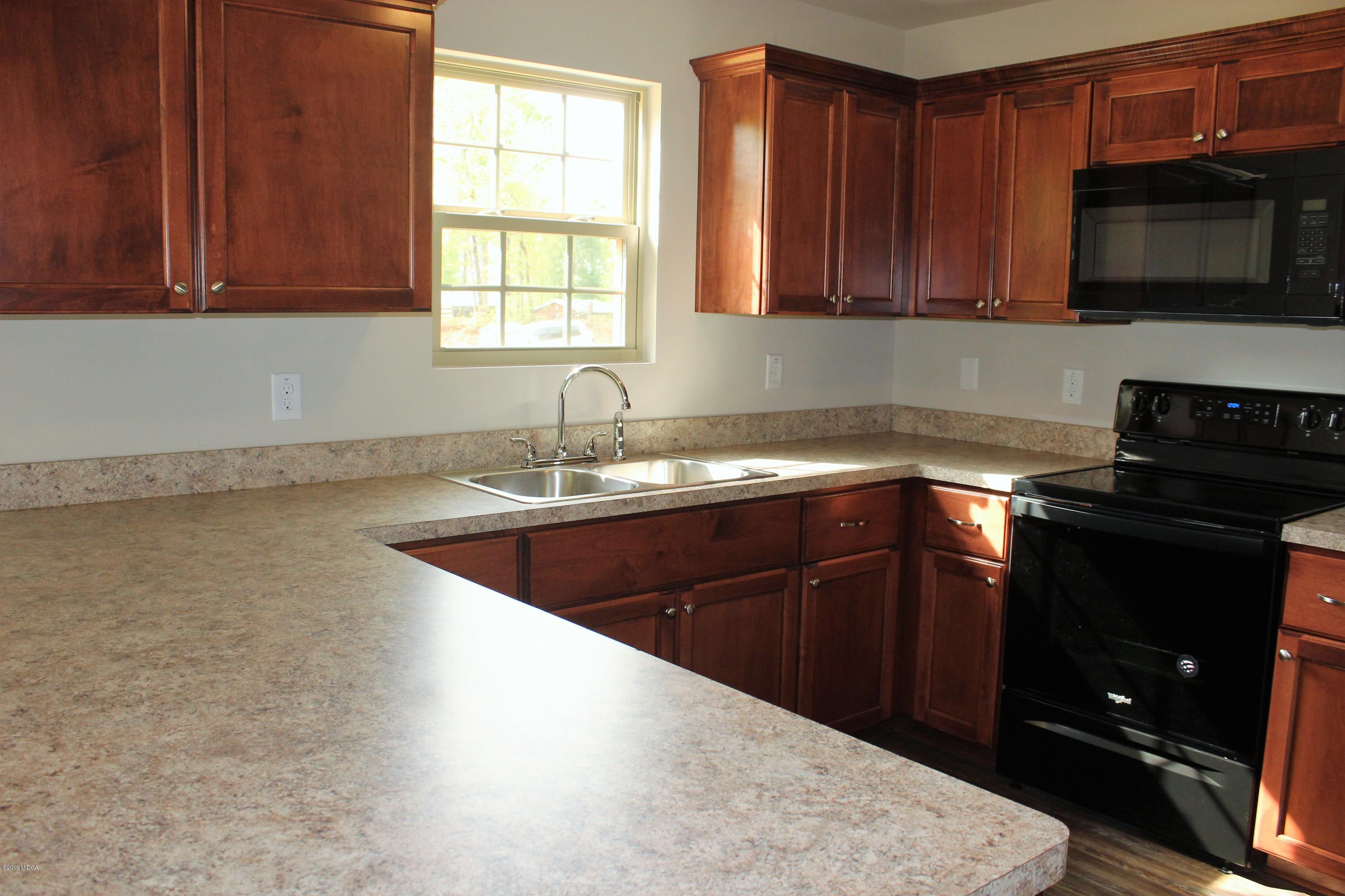 805 Weldon Road Forsyth, GA 31029 - Photo 4 of 5 a kitchen with granite countertop a sink stainless steel appliances and cabinets