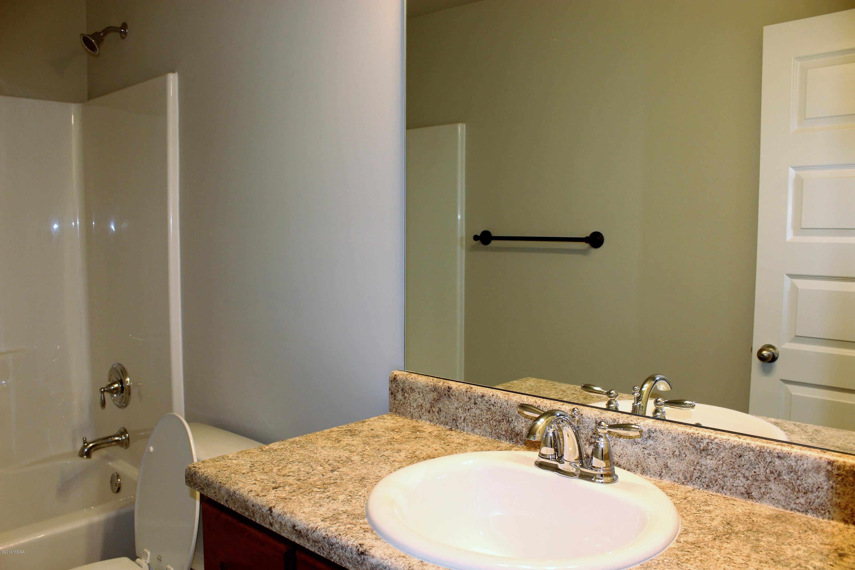 805 Weldon Road Forsyth, GA 31029 - Photo 5 of 5 a bathroom with a granite countertop sink and a mirror