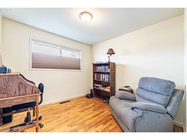 a bedroom with a bed a lamp and paintings on the wall