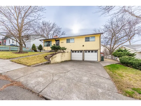 a view of a house with backyard and trees