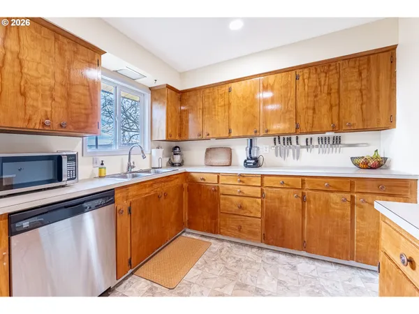 a kitchen with granite countertop wooden cabinets a sink and a window