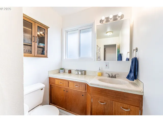 a bathroom with a sink a toilet and mirror