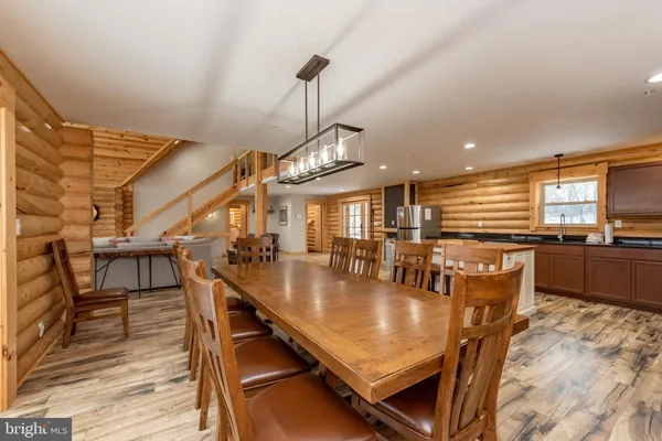 a dining room with furniture entryway and wooden floor