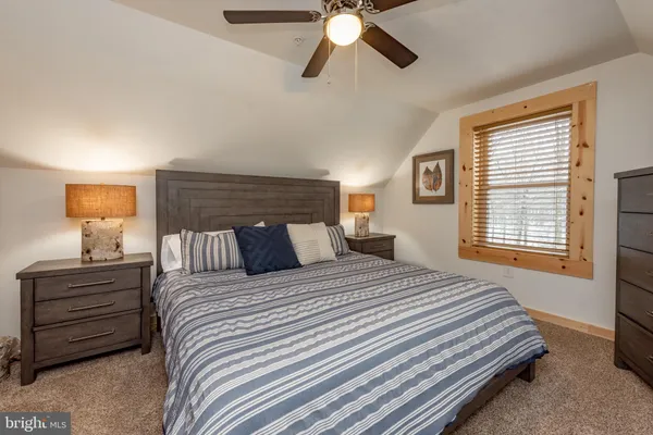 a bedroom with a bed and ceiling fan