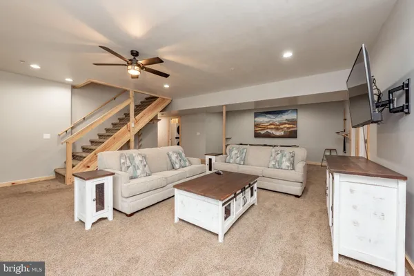 a living room with furniture and view of kitchen