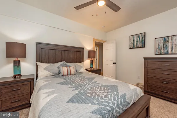 a bedroom with a bed and a ceiling fan