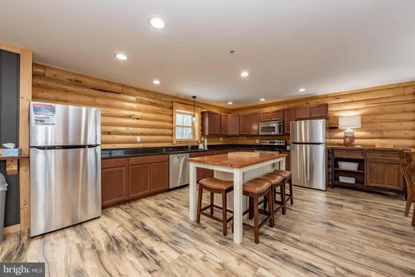 a kitchen with stainless steel appliances granite countertop a refrigerator a stove and a wooden floors