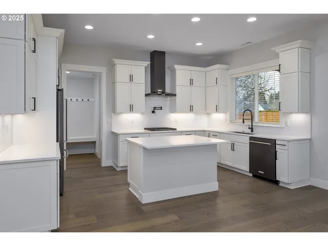 a kitchen with white cabinets and stainless steel appliances