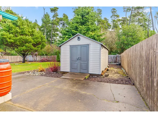 a view of a house with a yard plants and a large tree