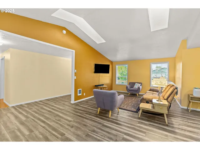 a living room with furniture wooden floor and a flat screen tv