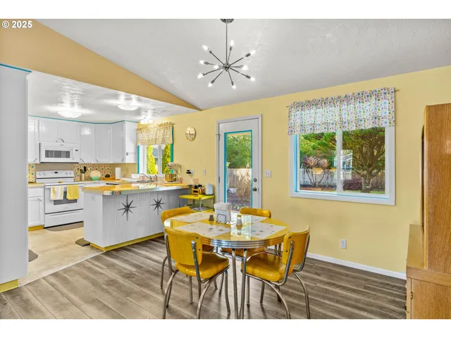 a open kitchen with stainless steel appliances kitchen island granite countertop a table chairs and a refrigerator