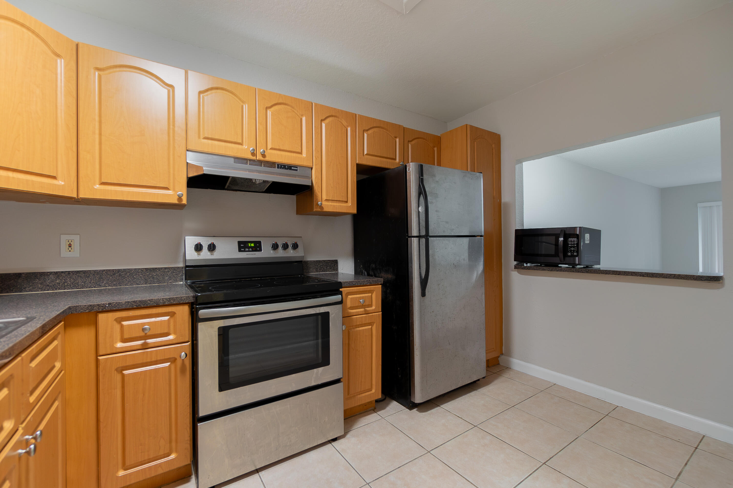 120 Sparrow Drive, Unit 314 Royal Palm Beach, FL 33411 - Photo 3 of 17 a kitchen with stainless steel appliances granite countertop a refrigerator stove and cabinets