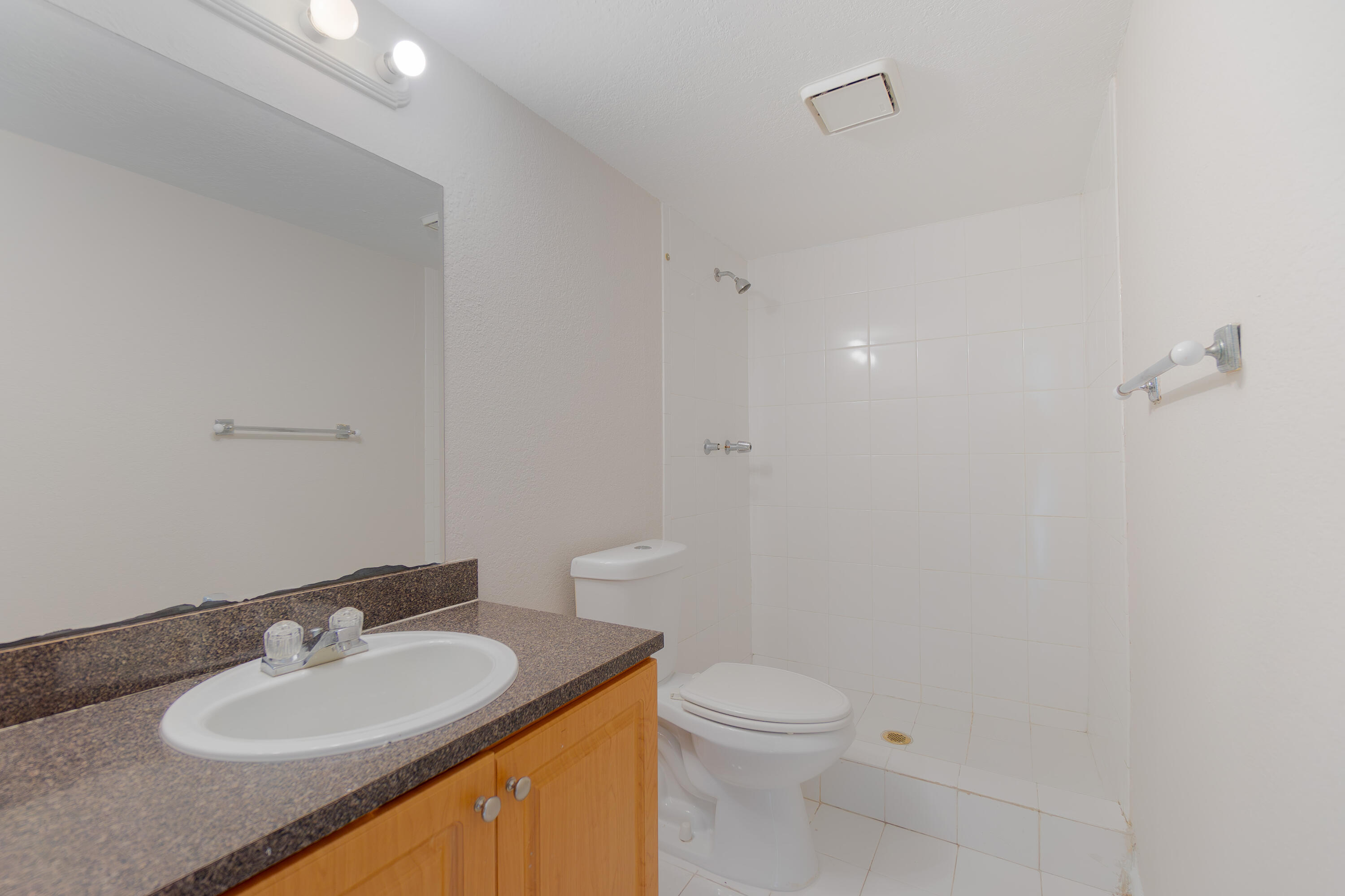 120 Sparrow Drive, Unit 314 Royal Palm Beach, FL 33411 - Photo 6 of 17 a bathroom with a granite countertop sink a toilet and a mirror