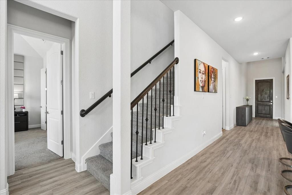 2721 Rotherham Street Prosper, TX 75078 - Photo 11 of 37 a view of a hallway with wooden floor and staircase