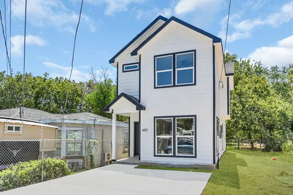 a view of a house with a yard and potted plants