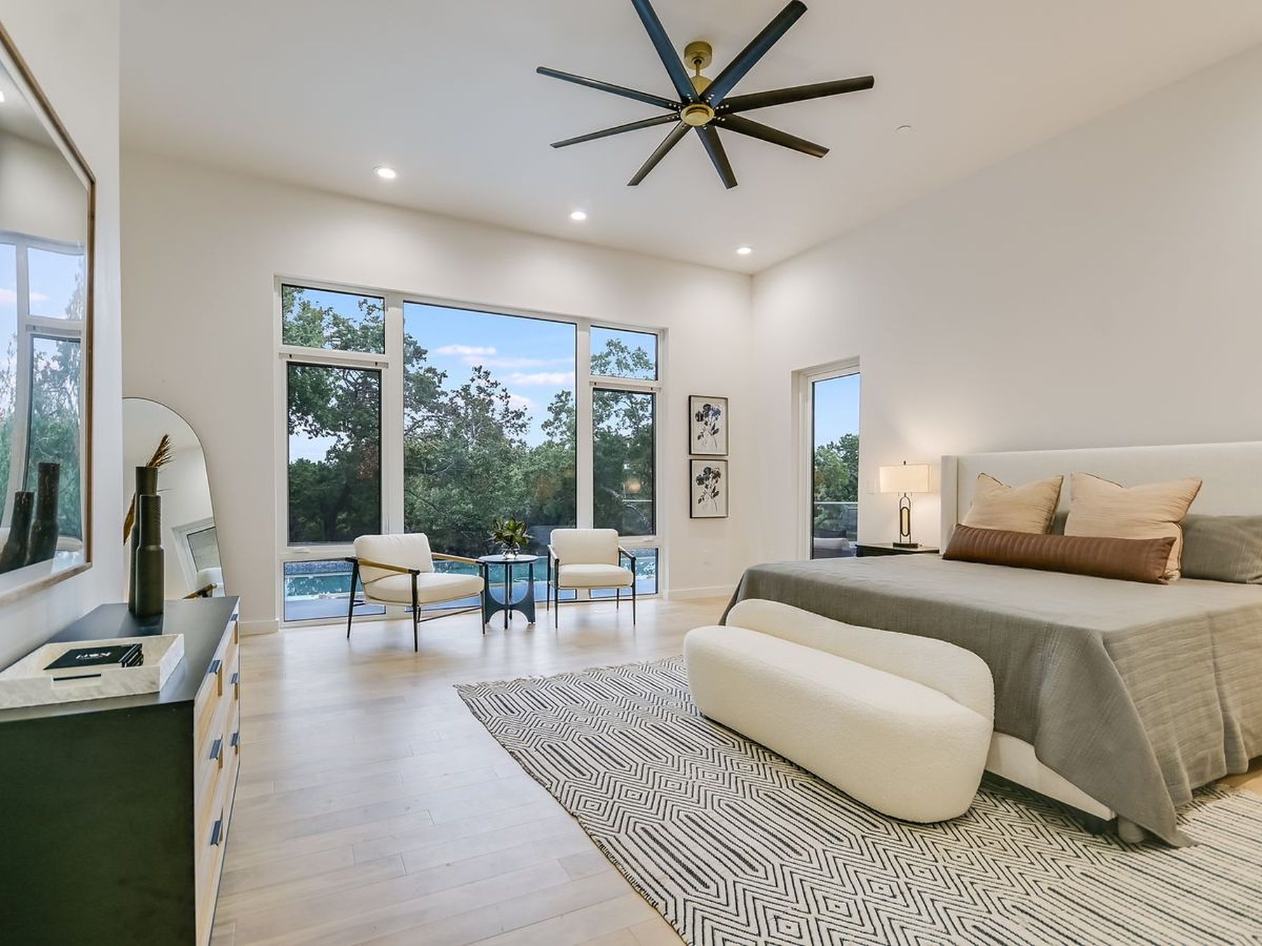 2476 Waymaker Way Austin, TX 78746 - Photo 11 of 31 Floor-to-ceiling windows offer serene outdoor views from this comfortable, naturally illuminated bedroom.