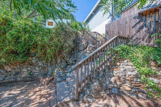 a view of a house with a yard and wooden fence