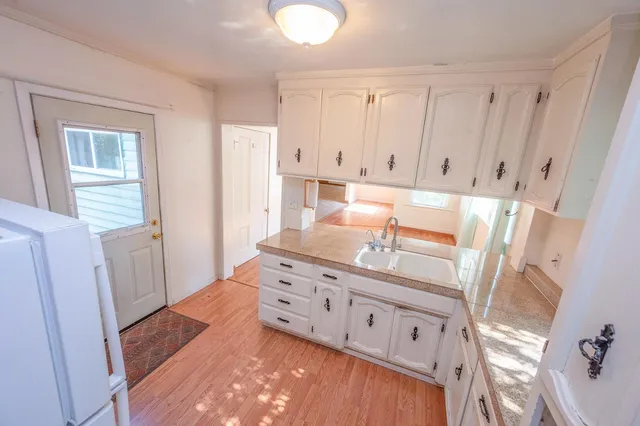 an empty room with windows and chandelier fan