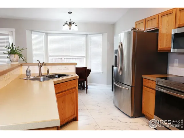 a kitchen with stainless steel appliances granite countertop a refrigerator a stove a sink and a microwave