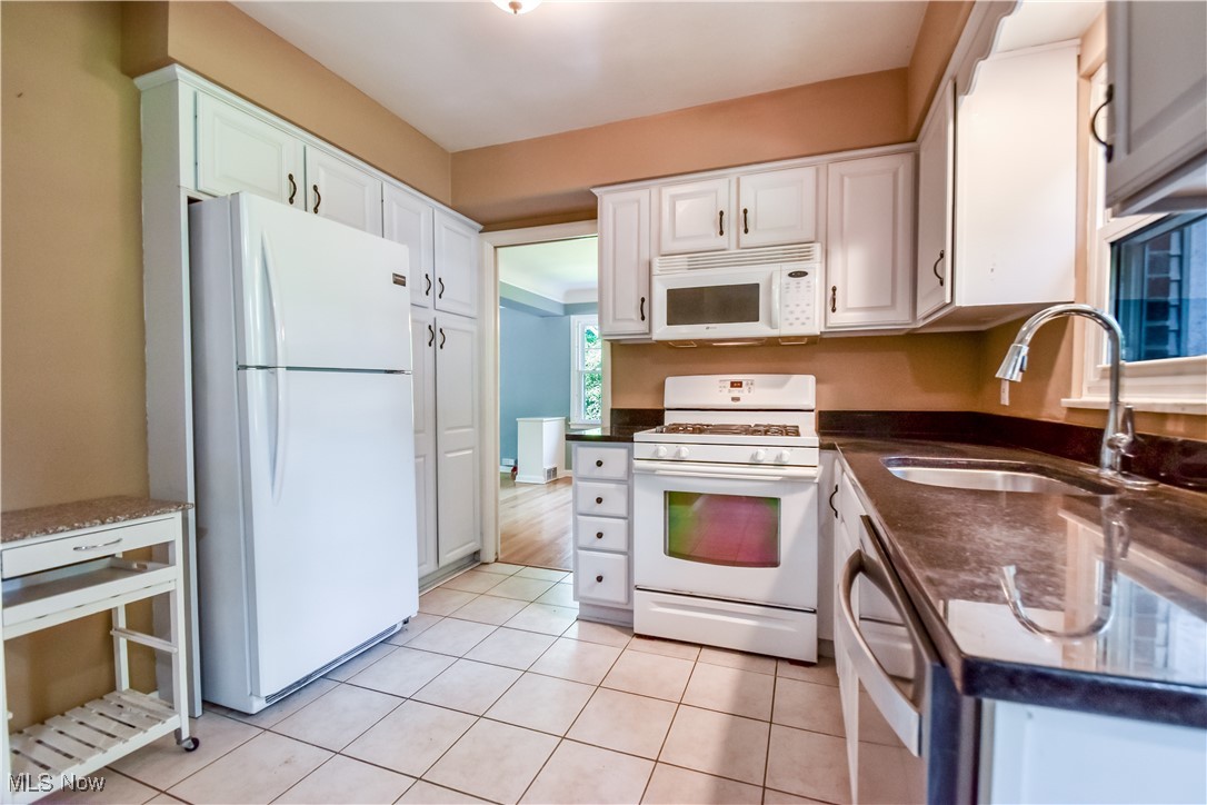 2607 Ashurst Road University Heights, OH 44118 - Photo 24 of 39 Kitchen featuring white appliances, white cabinets, and light tile patterned floors