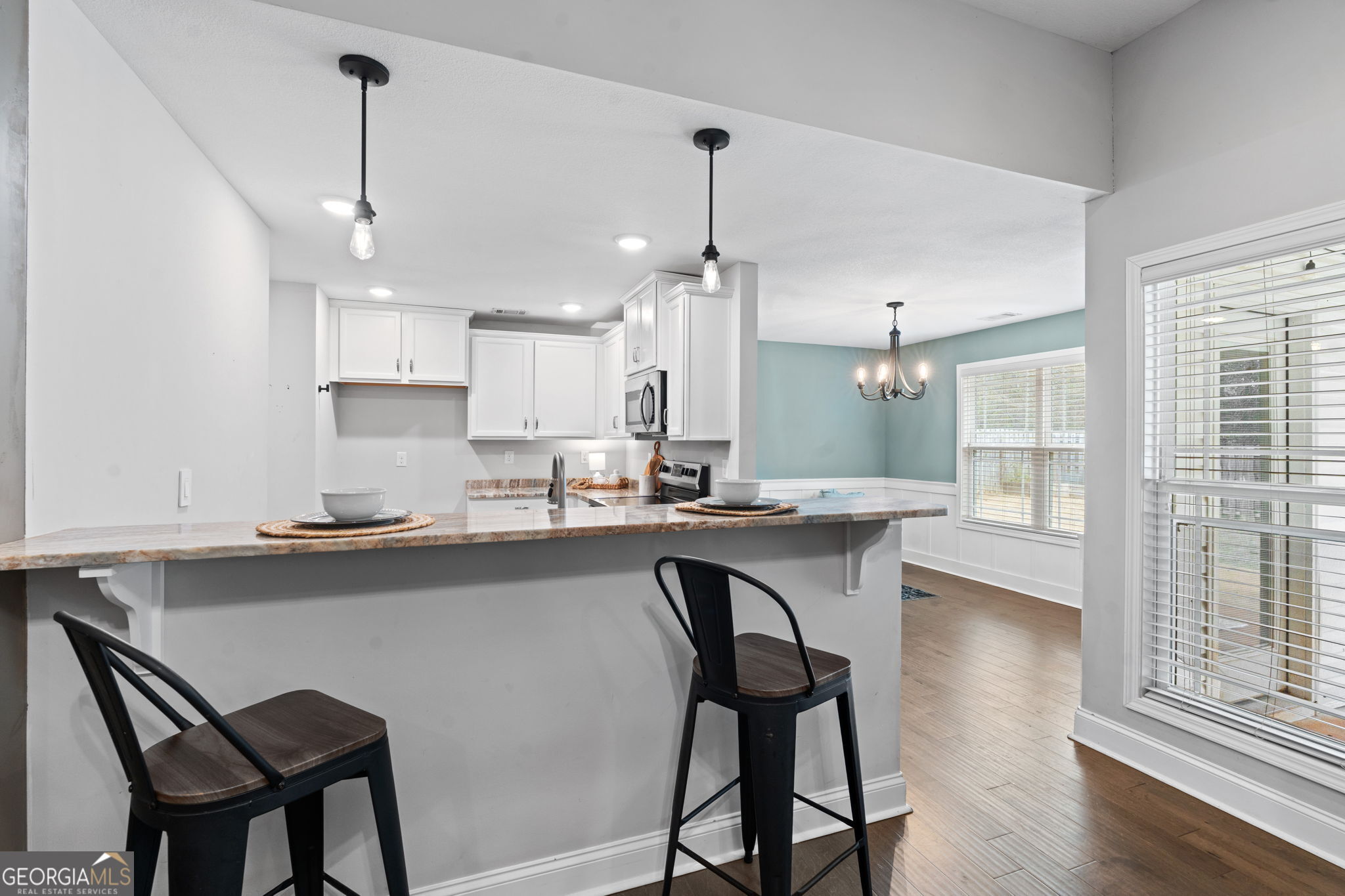 171 Hawks Rdg Trace Byron, GA 31008 - Photo 8 of 34 a kitchen with stainless steel appliances granite countertop white cabinets a table and chairs