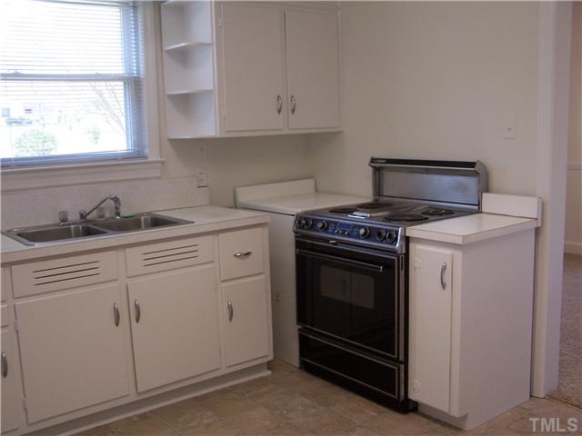 108 Lord Berkley Road Raleigh, NC 27610 - Photo 9 of 24 a kitchen with white cabinets and a stove top oven