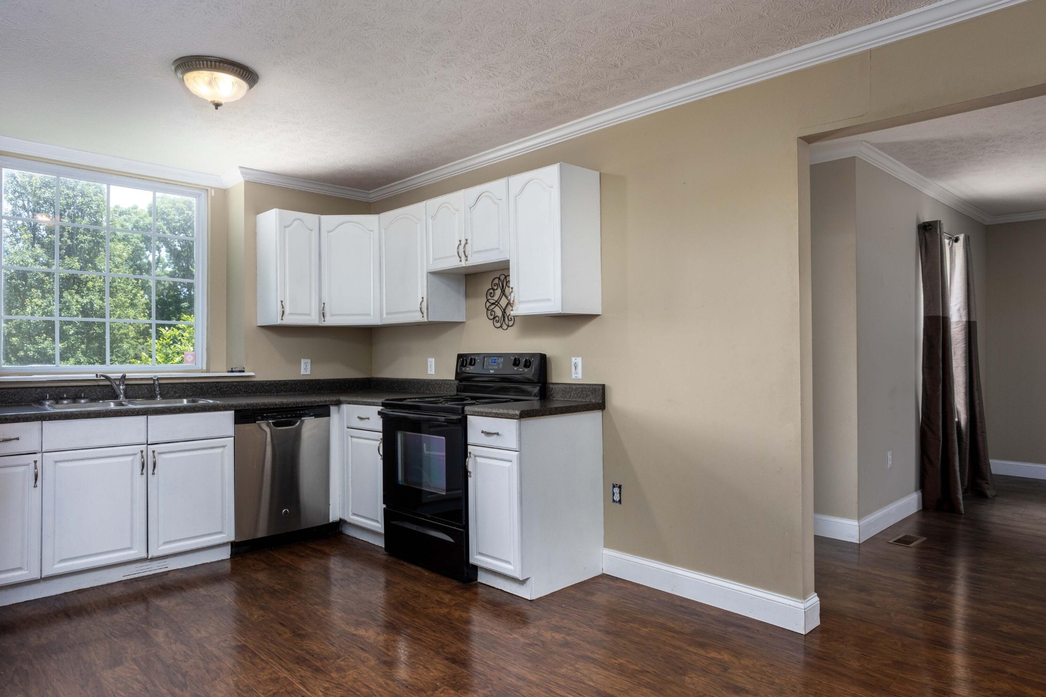1165 Possum Trot Road Grandview, TN 37337 - Photo 16 of 48 a kitchen with granite countertop white cabinets and wooden floor