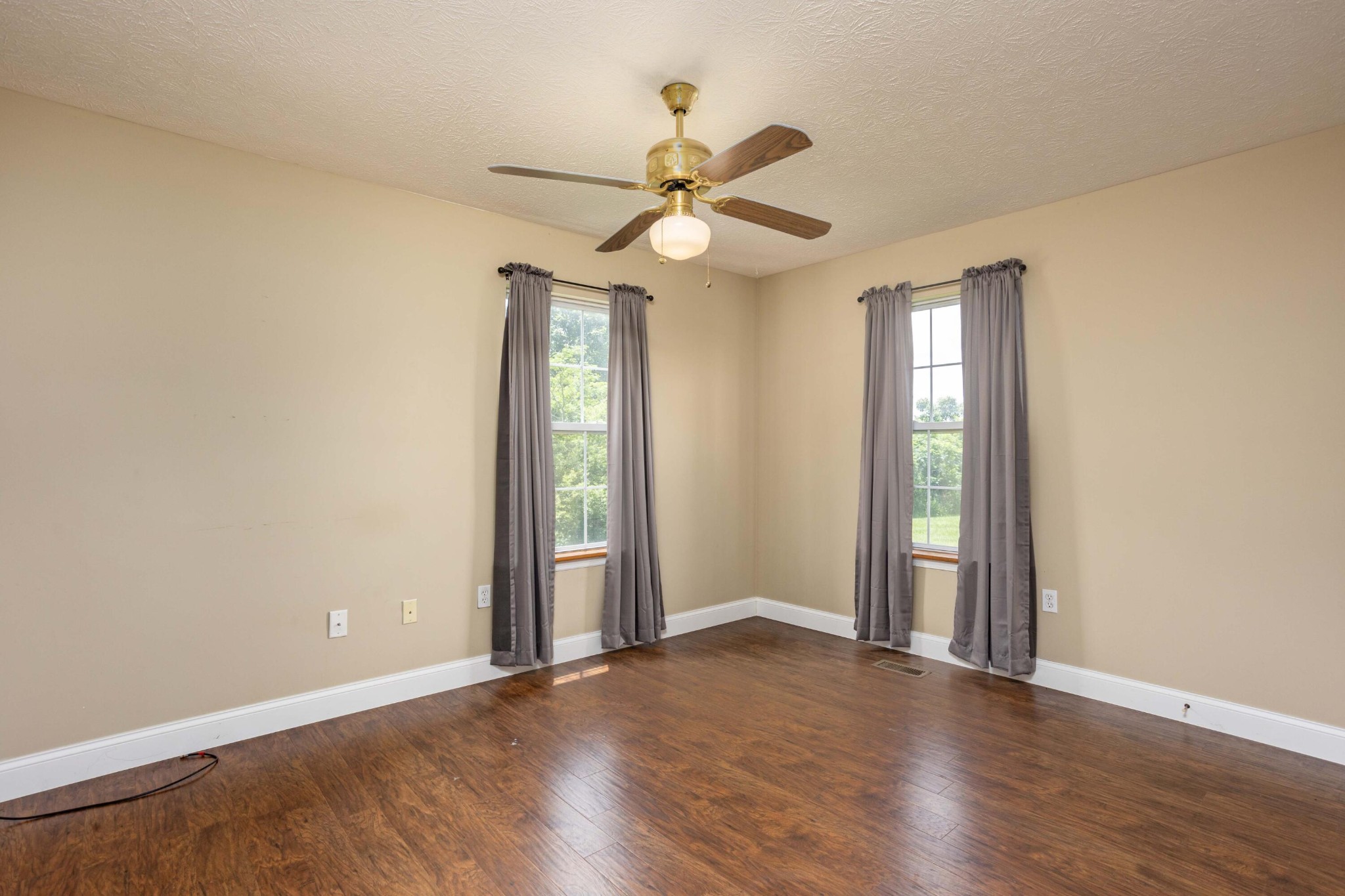 1165 Possum Trot Road Grandview, TN 37337 - Photo 25 of 48 an empty room with wooden floor fan and windows