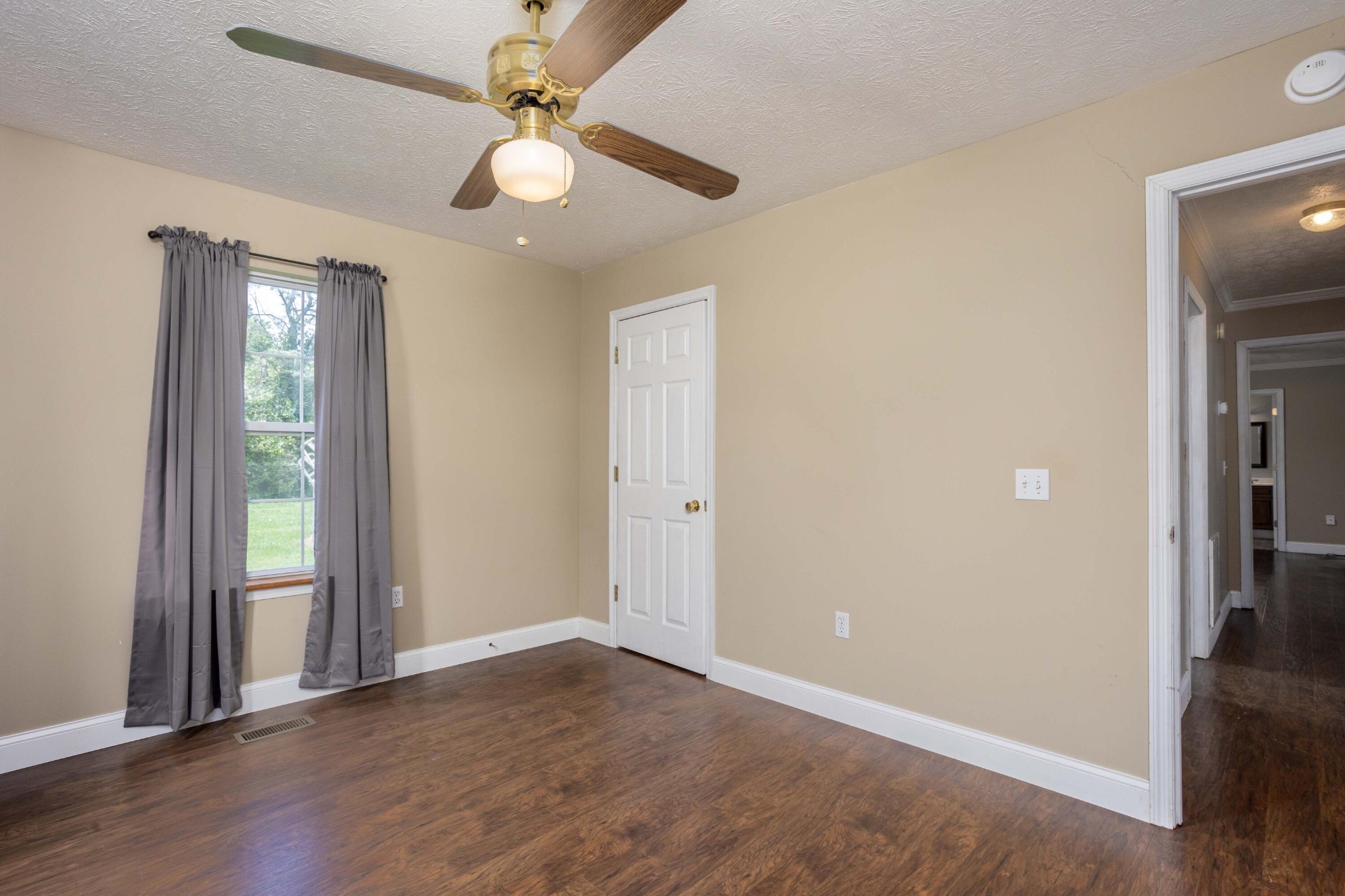 1165 Possum Trot Road Grandview, TN 37337 - Photo 26 of 48 an empty room with wooden floor and ceiling fan