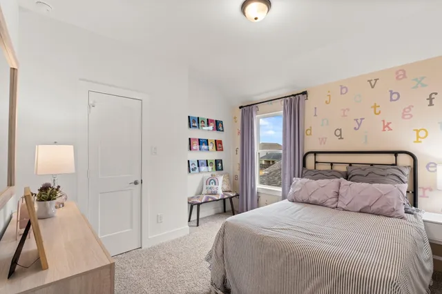 a bedroom with a bed and a flat tv screen on the dresser