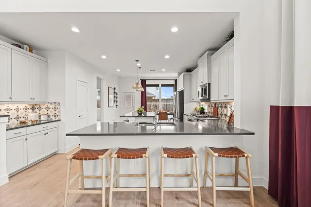 a kitchen with stainless steel appliances granite countertop counter space and chairs