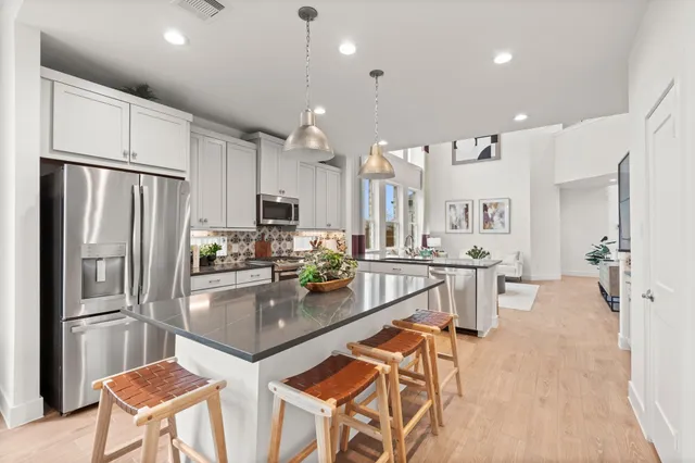 a kitchen with stainless steel appliances granite countertop a refrigerator and a stove top oven