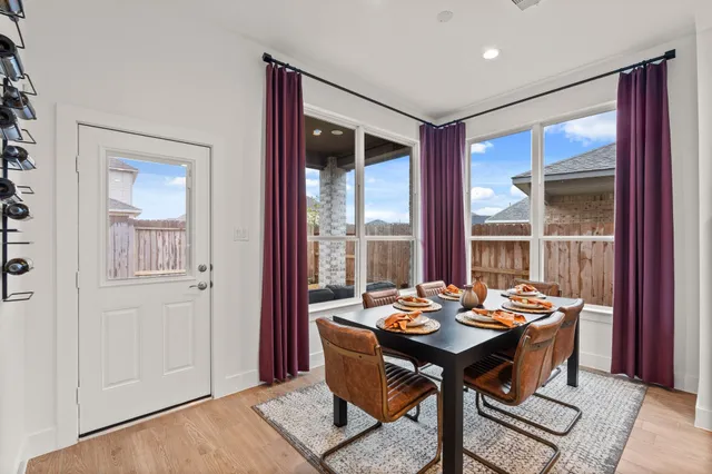 a view of a dining room with furniture large windows and a chandelier