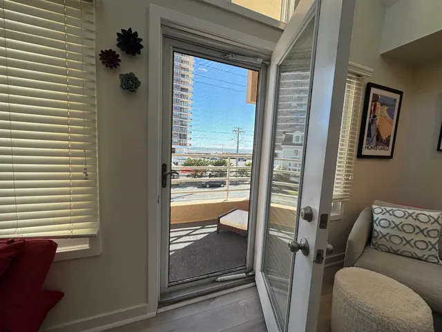 a living room with stainless steel appliances furniture and a flat screen tv