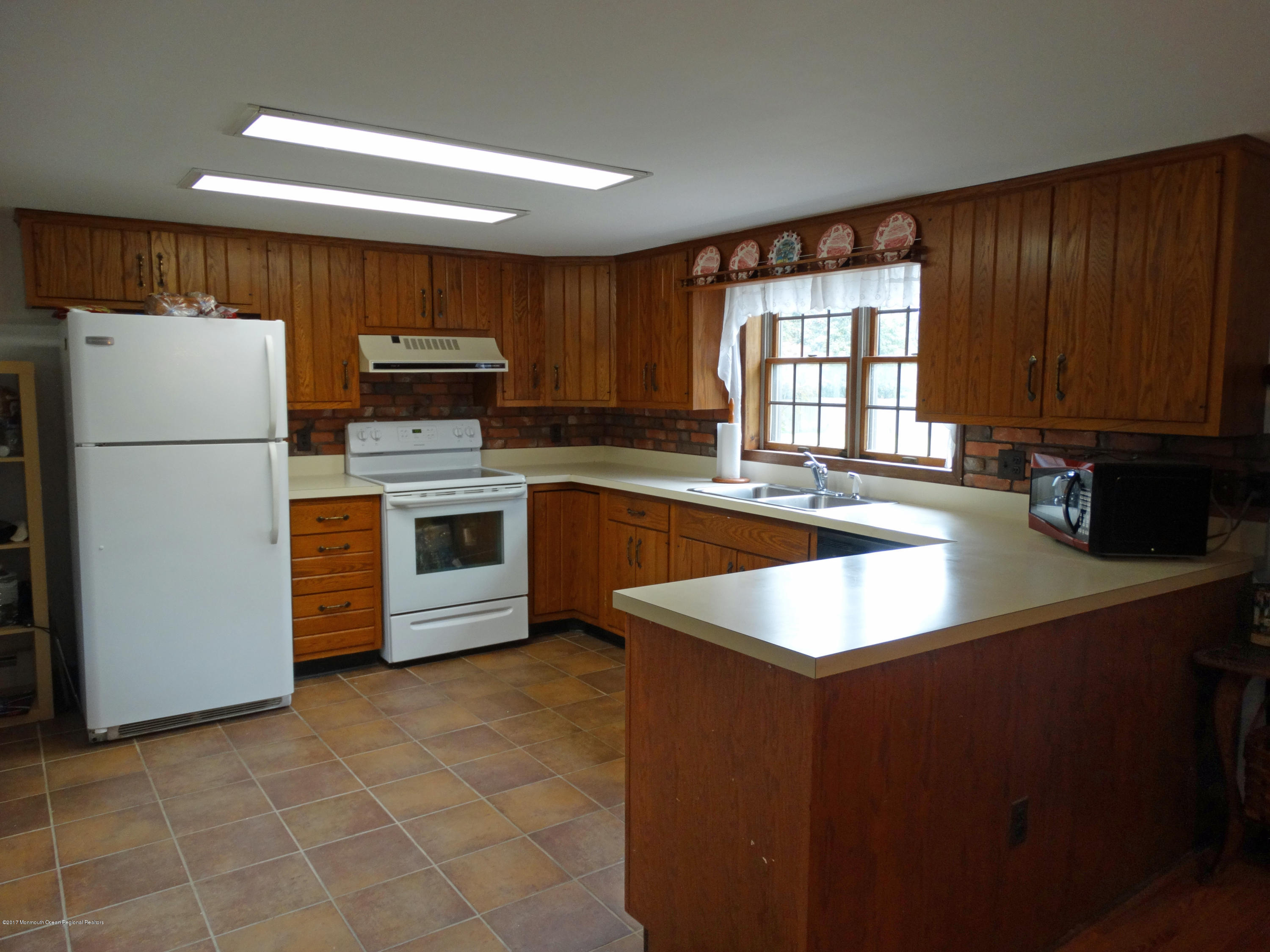 850 Adelphia Road Freehold, NJ 07728 - Photo 7 of 25 a kitchen with a refrigerator a stove a sink and a window