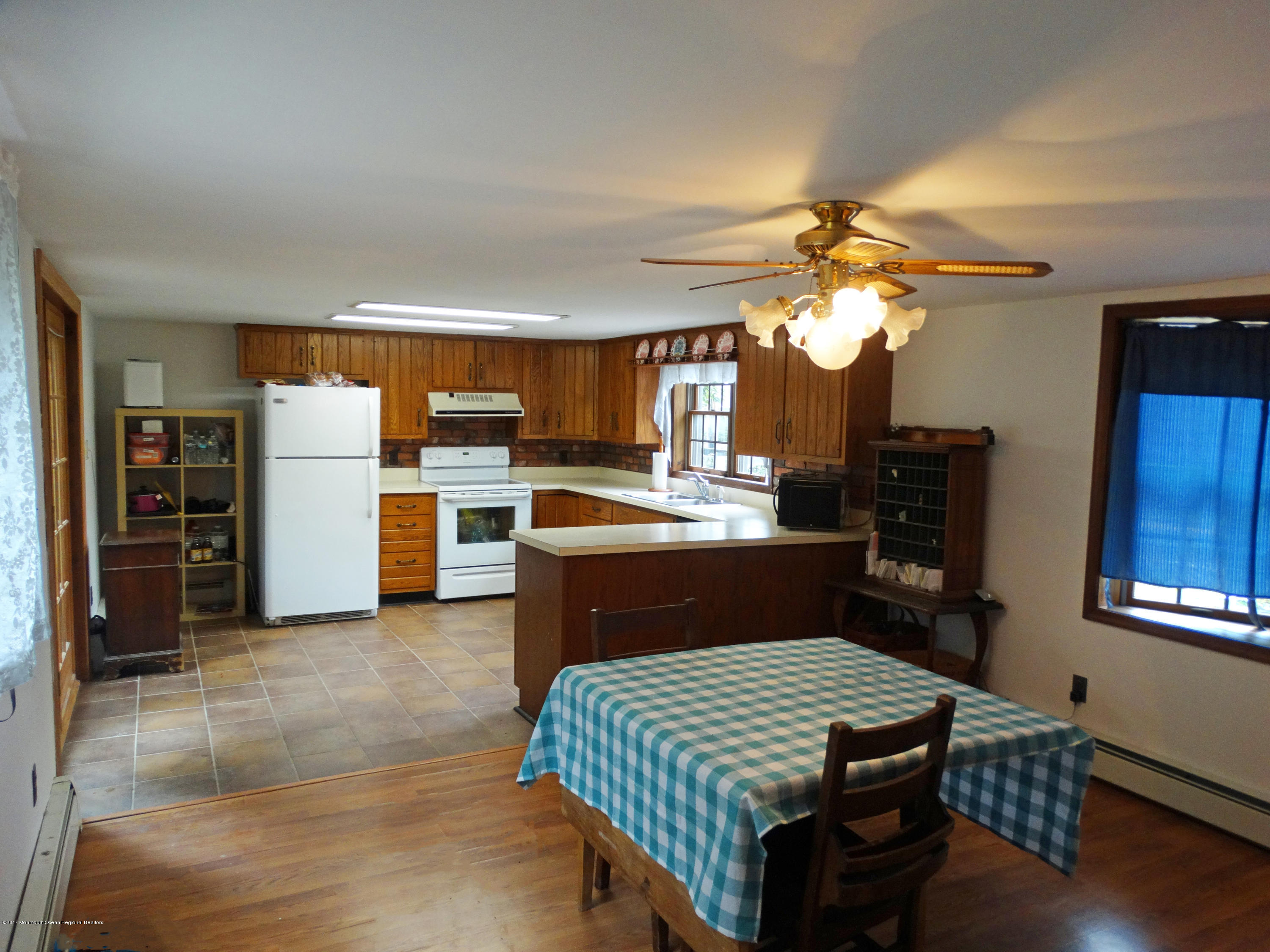 850 Adelphia Road Freehold, NJ 07728 - Photo 10 of 25 a kitchen with a refrigerator a stove microwave oven with a dining table and chairs
