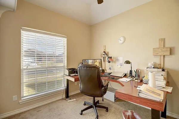 a view of a workspace with furniture and a window